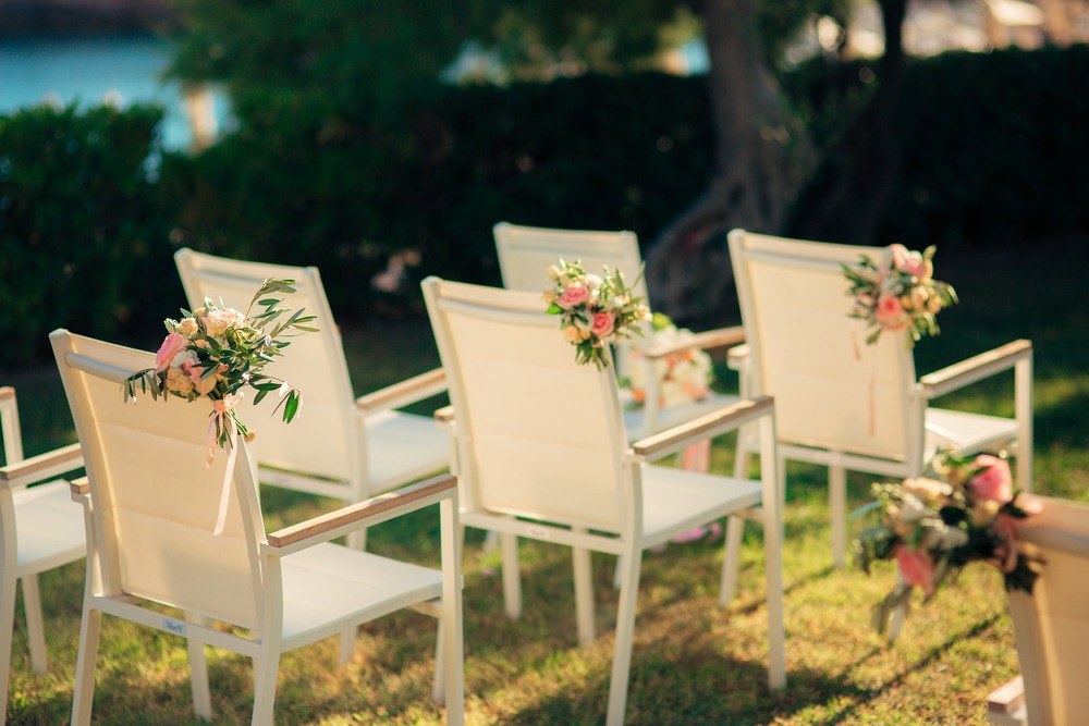 chairs decorated with flowers for a wedding ceremony